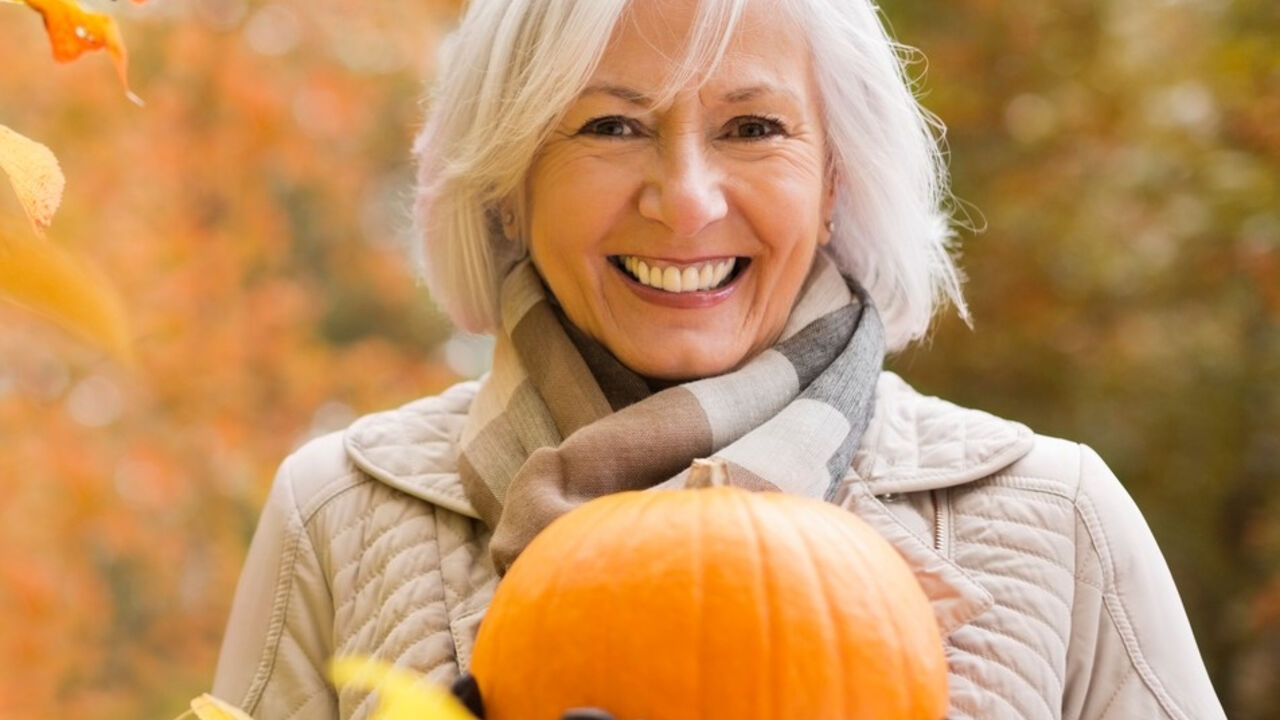 Starija žene drži bundevu