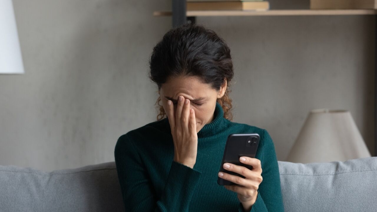 tuzna zena gleda u telefon