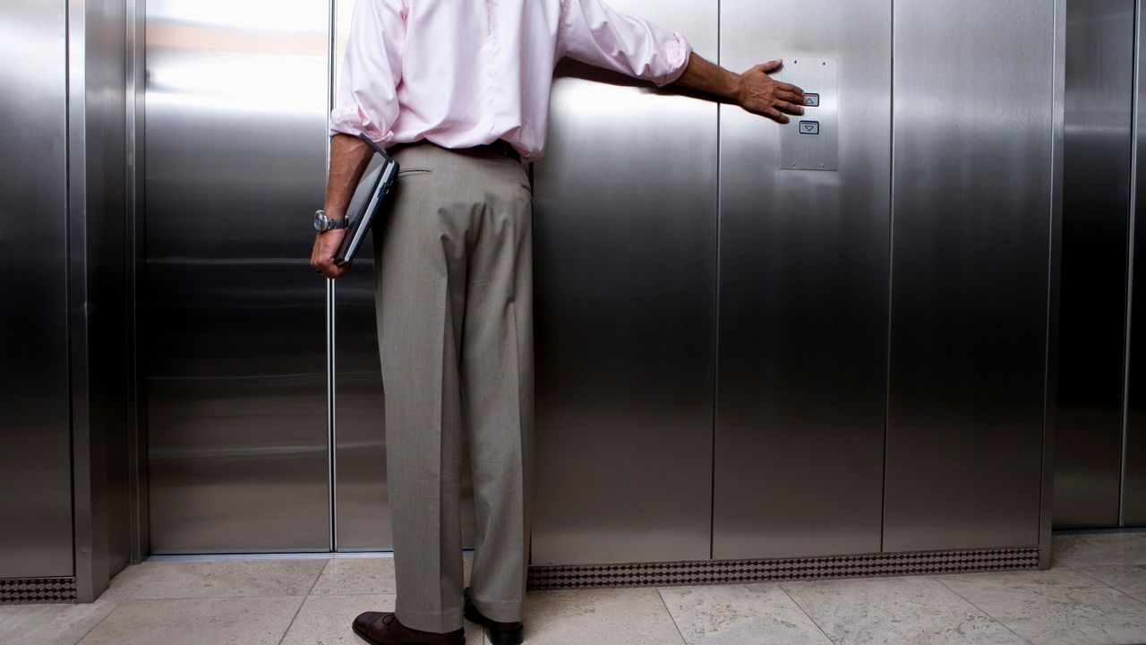 Čovek pritiska dugme za lift
