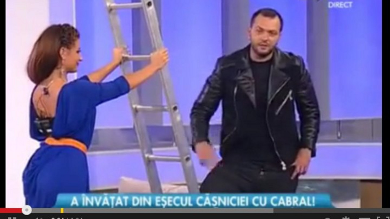 Voditeljka drži merdevine, voditelj se priprema za penjanje