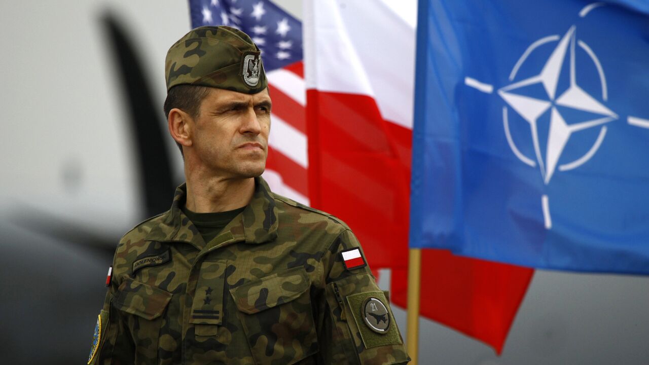 Vojnik ispred zastave NATO i Poljske
