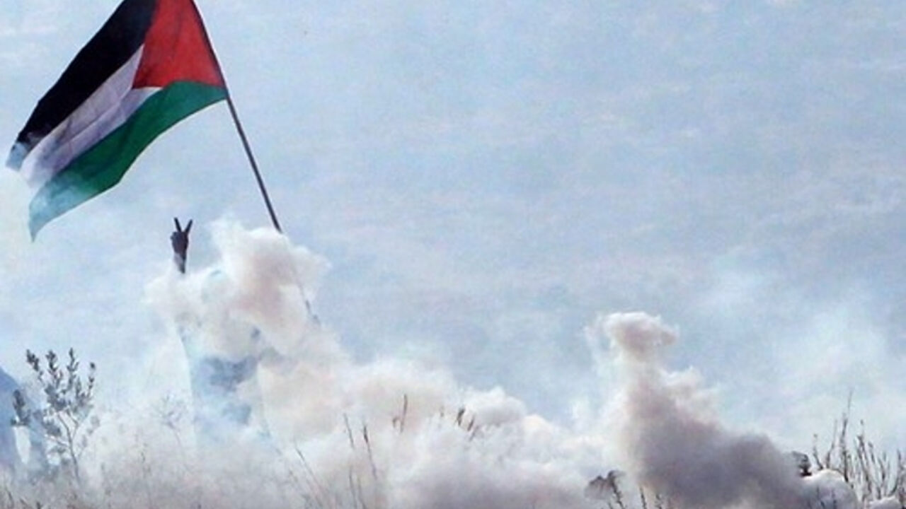 Palestinac maše zastavomtokom sukoba sa Izraelcima