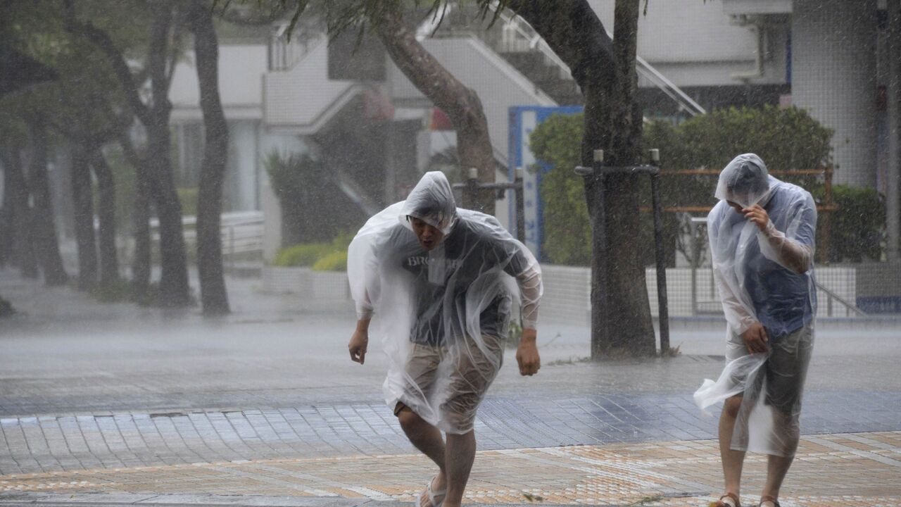 ljudi sa kabanicama trče po kiši, nevreme