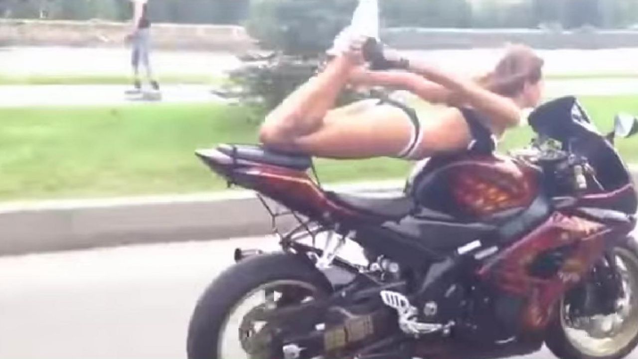 Devojka vozi motor i vežba jogu