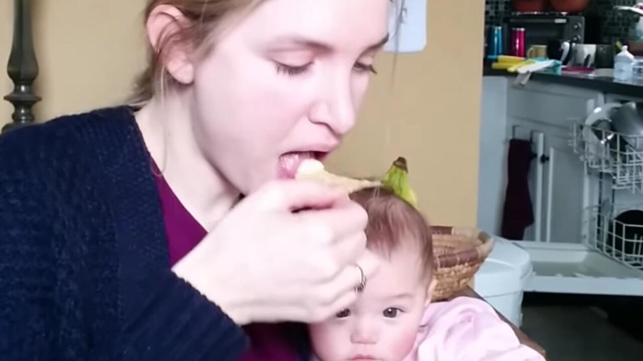 Mama jede čips pored bebe
