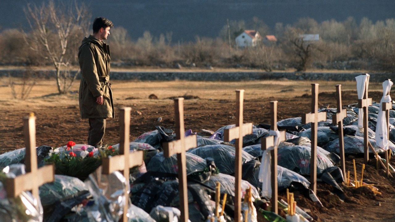 Vojnik plače pored srpskih grobova