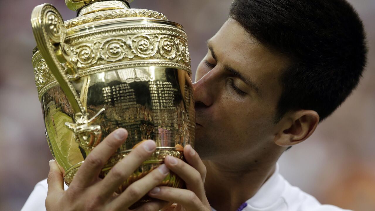 Novak Đoković ljubi pehar posle osvajanja Vimbldona