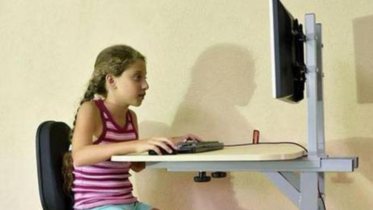 devojčica sedi za kompjuterom