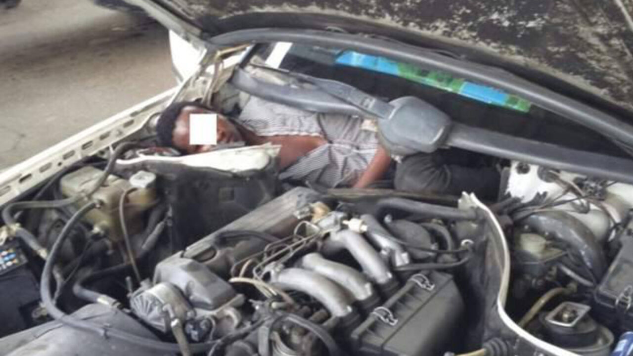 Migrant skriven ispod haube automobila