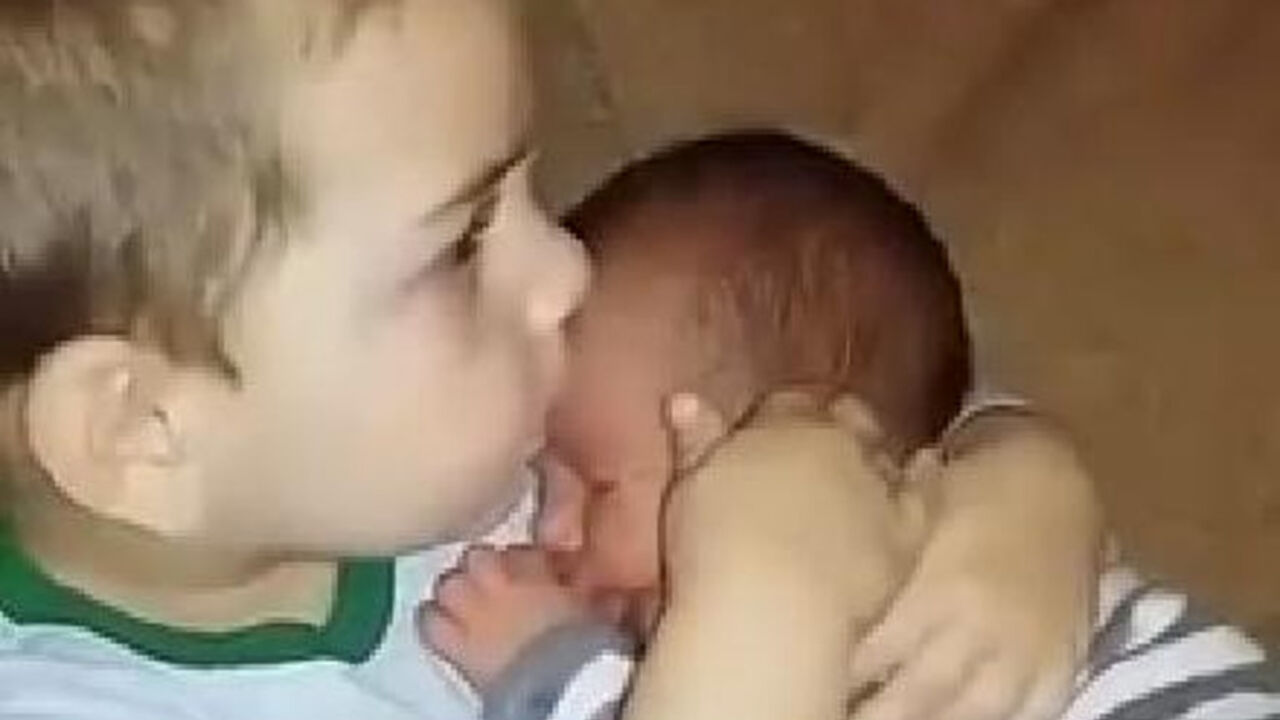 dečak grli svog brata bebu