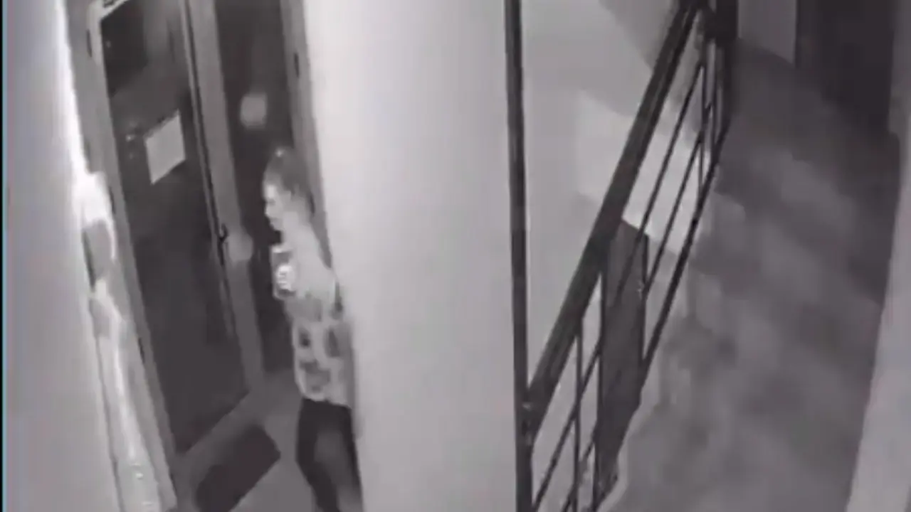 Devojka nogom pali svetlo u zgradi